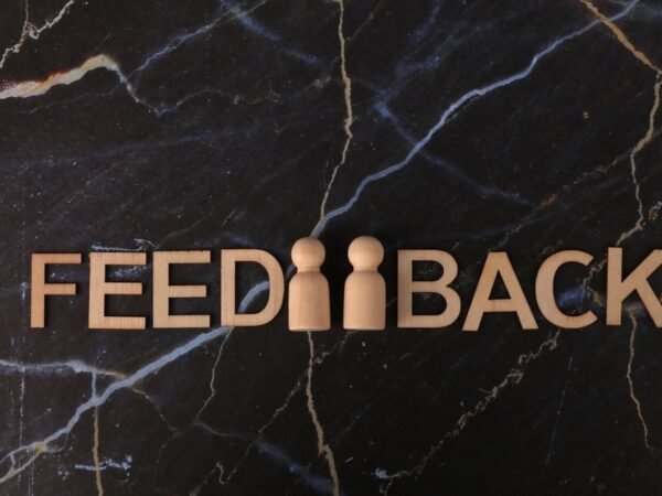 Feedback concept with wooden letters on a dark marble surface.