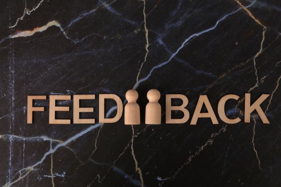 Feedback concept with wooden letters on a dark marble surface.