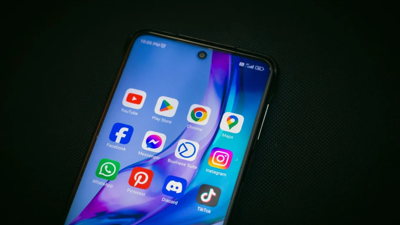 Tela de smartphone exibindo ícones de aplicativos populares, incluindo o Google Maps, em fundo preto